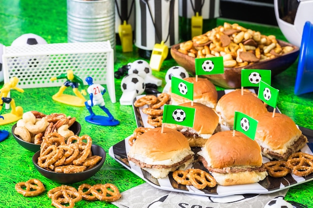 Salty snacks and beer on the table for soccer party.