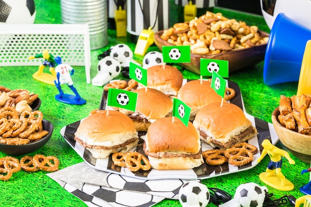 Salty snacks and beer on the table for soccer party.