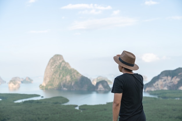 Samed Nang Chee. Man with view of the Phang Nga bay, mangrove tree forest and hills at Andaman sea, Thailand.