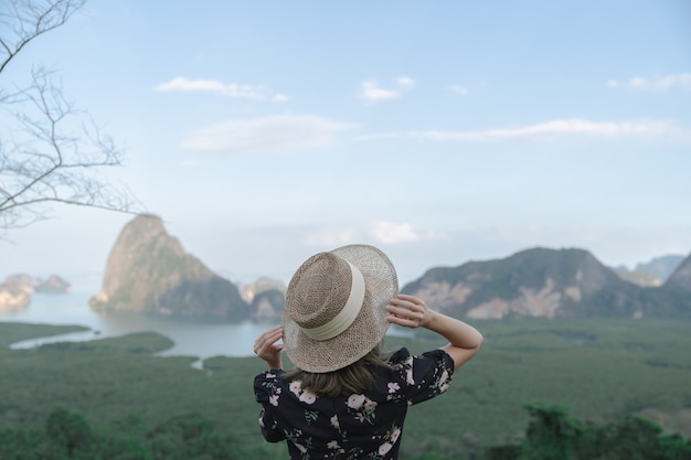 Samed Nang Chee. Woman with view of the Phang Nga bay, mangrove tree forest and hills at Andaman sea, Thailand.