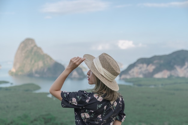 Samed Nang Chee. Woman with view of the Phang Nga bay, mangrove tree forest and hills at Andaman sea, Thailand.