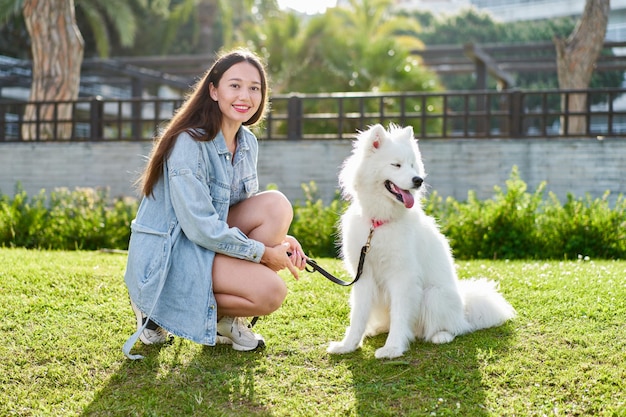 Samoyed dog with her female owner at the park playing together