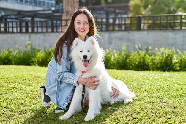 Samoyed dog with her female owner at the park playing together