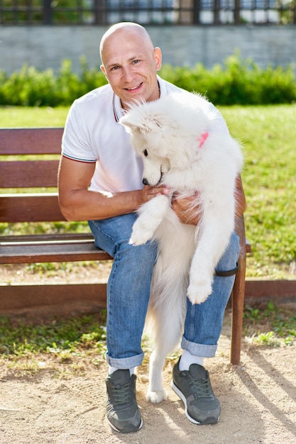 Samoyed dog with her man owner at the park playing together