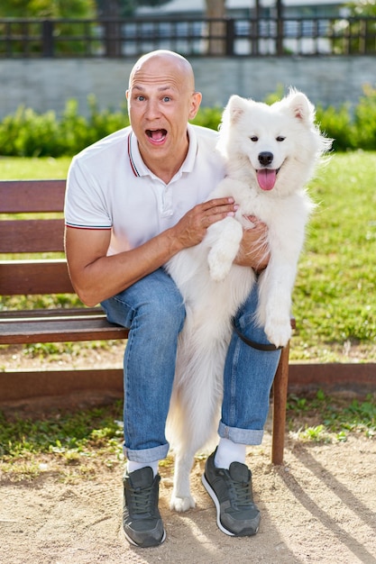 Samoyed dog with her man owner at the park playing together