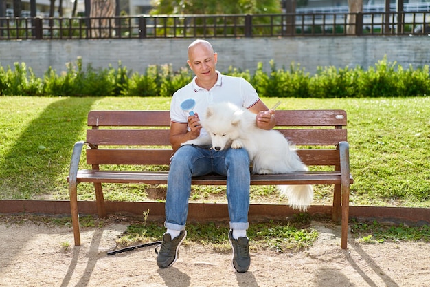 Samoyed dog with her man owner at the park playing together