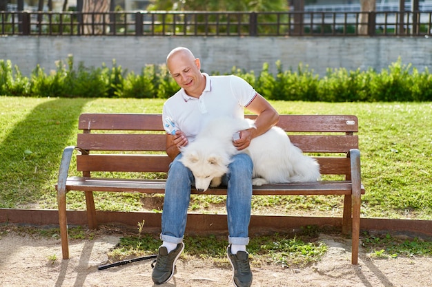 Samoyed dog with her man owner at the park playing together