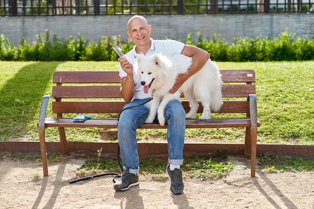 Samoyed dog with her man owner at the park playing together