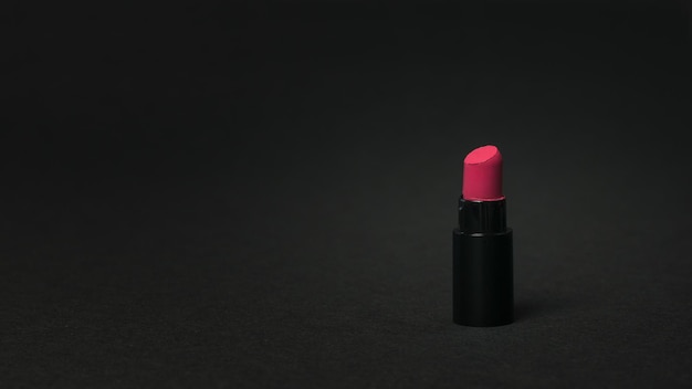 A sample of bright red lipstick on a black background