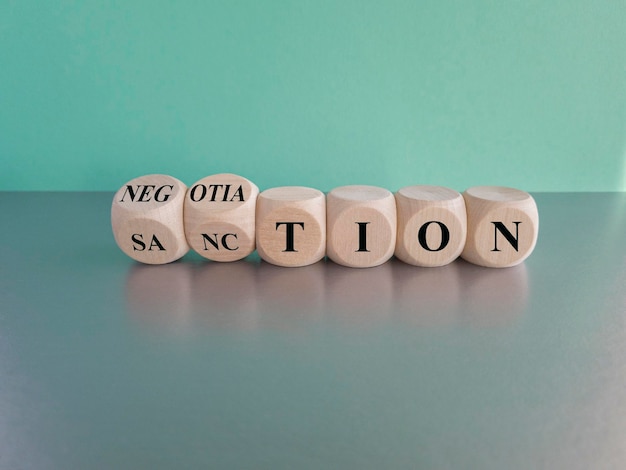 Sanction or negotiation symbol Turned cubes and changes the word sanction to negotiation