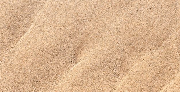 Sand Beach Texture Background in Summer Top view Brown Sandy Rough Surface with Wave Ripple of Sea Water with copy space for Summer banner designNatural Sand Stone by the Sea