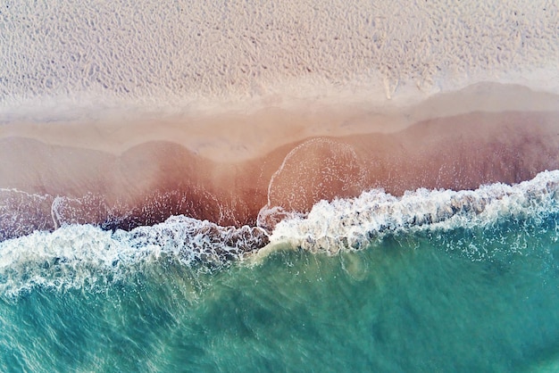 Sand beach with sea waves top view summer vacation and travel concept beautiful coastline with blue