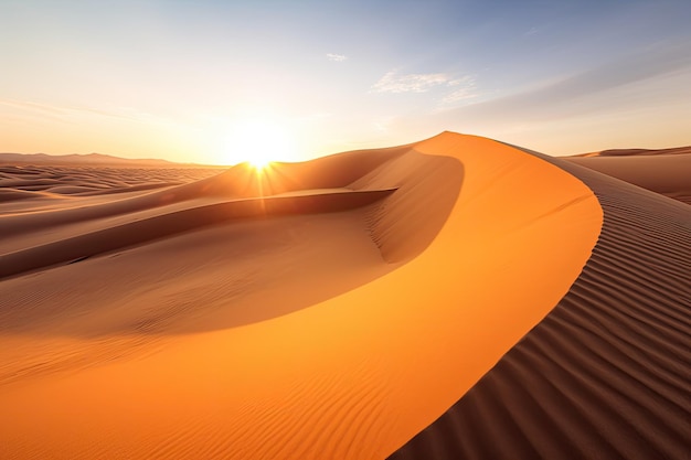 a sand dune with the sun setting behind it