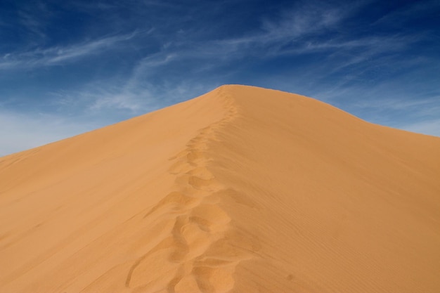 Sand dunes at desert against sky