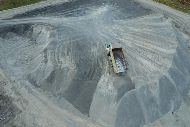 Sand loaders are shoveling rocks into dump trucks