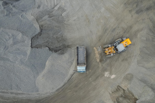 Sand loaders are shoveling rocks into dump trucks