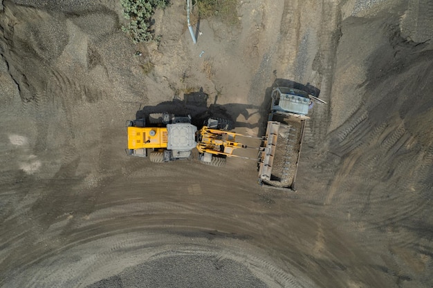 Sand loaders are shoveling rocks into dump trucks