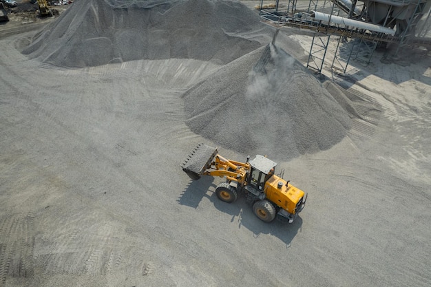 Sand loaders are shoveling rocks into dump trucks