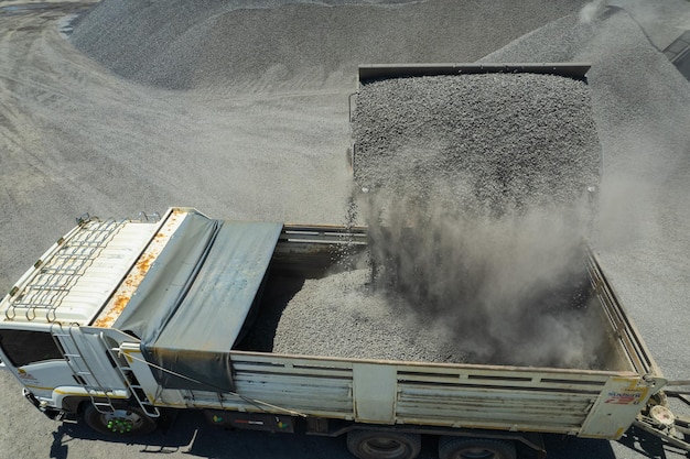 Sand loaders are shoveling rocks into dump trucks