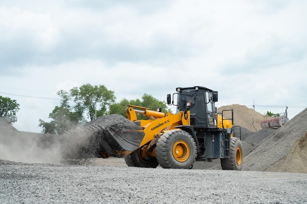 Sand loaders are shoveling rocks into dump trucks