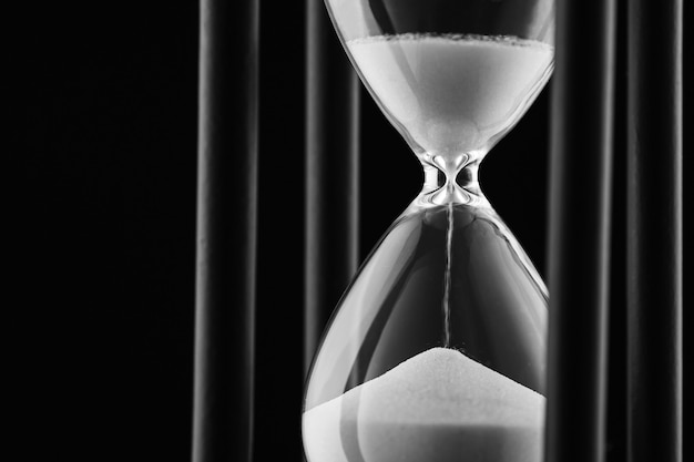 Sand running through a clear glass hourglass