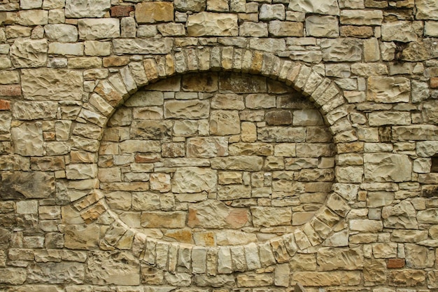 a sand stone wall with an oval shaped niche