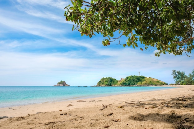 Sand, turquoise sea and blue sky with clouds