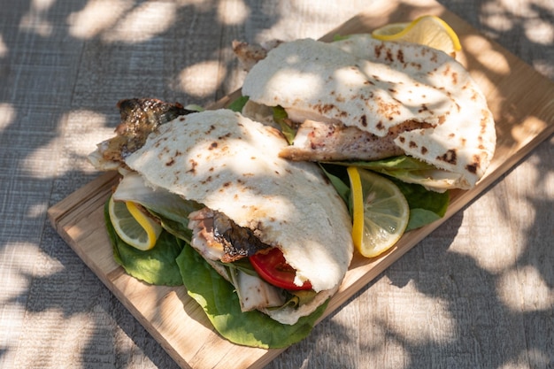 Sandwich balik ekmek with grilled fillet of mackerel tomatoes onions and lettuce