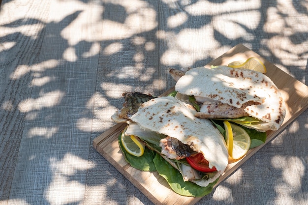 Sandwich balik ekmek with grilled fillet of mackerel tomatoes onions and lettuce