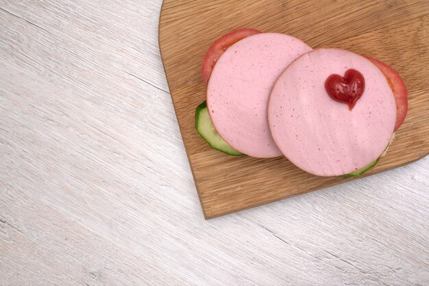 Sandwich  and chopped peppers on wooden board