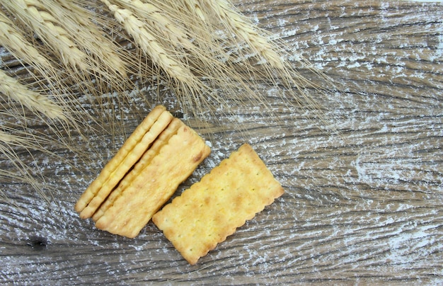 Sandwich crackers with cream and barley plant on wood table