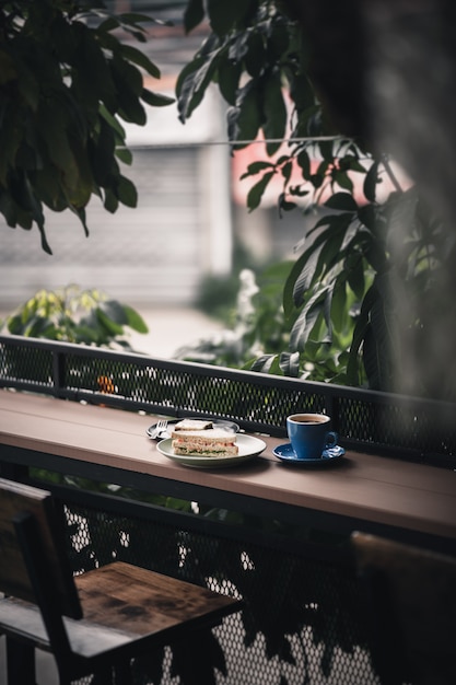 Sandwich and hot coffee on wood bar