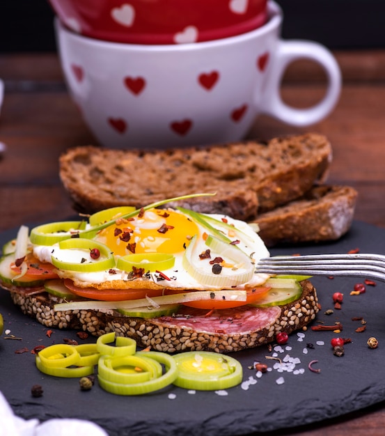 Sandwich made of rye bread, roasted egg, smoked sausage