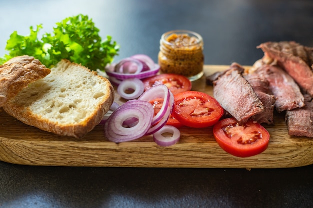 Sandwich meat and vegetables loaf of bread, tomato, lettuce