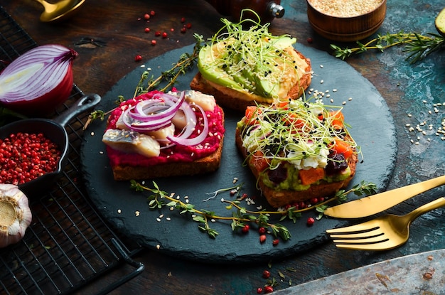 Sandwich menu ciabatta avocado fish hummus and microgreen Breakfast On a black stone plate