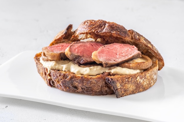 Sandwich with beef steak and mushrooms