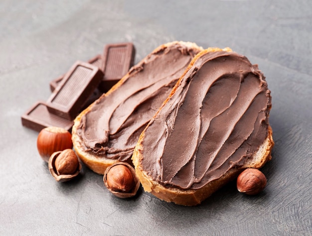 Sandwich with chocolate paste with filbert nuts on concrete backgrounds