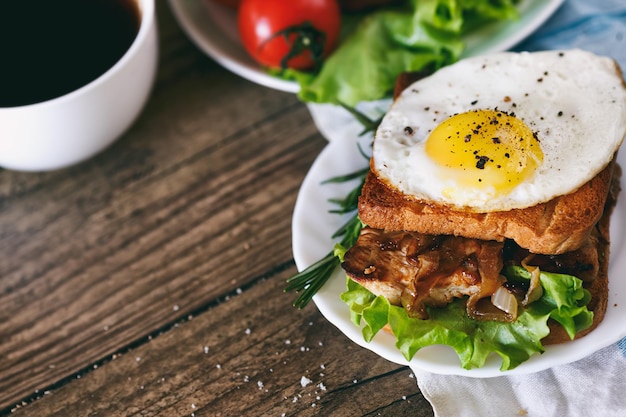 Sandwich with eggs chicken cucumber and lettuce on a wooden background Selective focus copy space