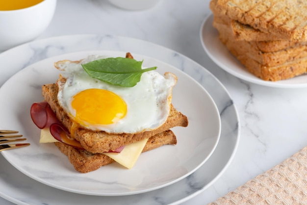 Sandwich with a fried egg bacon cheese and spinach