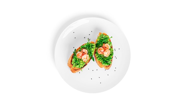 Sandwich with guacamole, shrimps, arugula, tomatoes, cucumber isolated. Bruschetta with avocado. Healthy breakfast