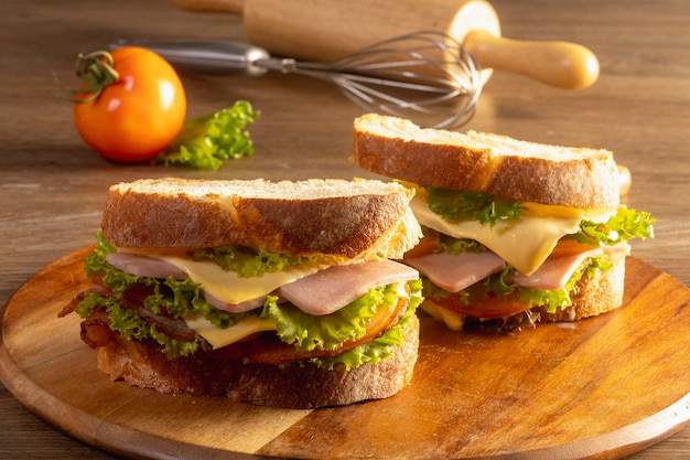 Sandwich with ham and vegetables on a wooden table