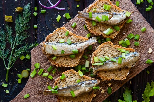 Sandwich with sardines,  onions on a cutting board