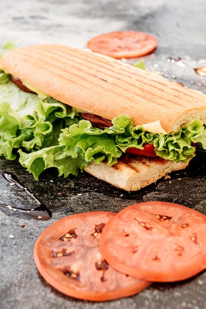 Sandwich with sausage, pepper, cheese and salad 