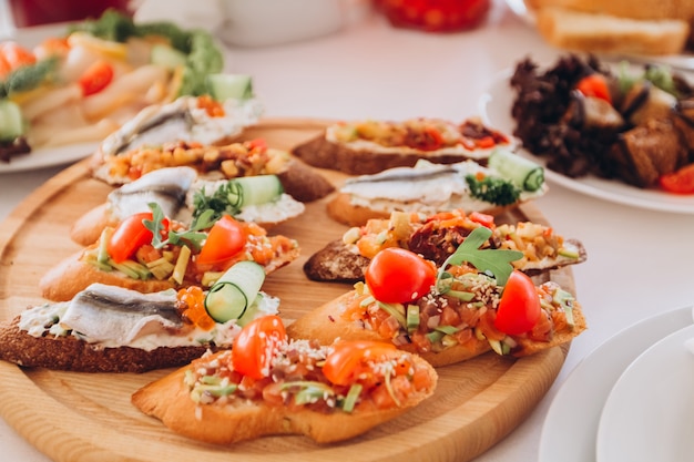 Sandwich with trout, cherry tomatoes and lettuce. plate of snacks.