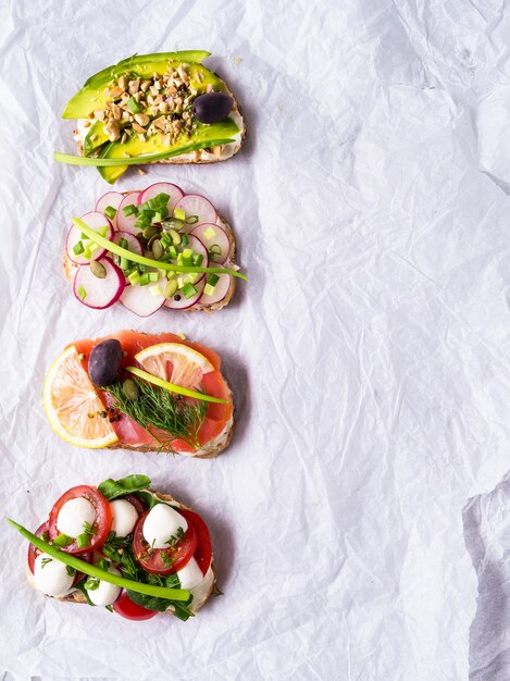 Sandwiches or tapas with bread, cream cheese, vegetable. 