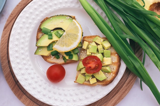 Sandwiches with avocado, tomatoes and herbs on a wooden background on the table. concept of healthy eating and vegetarianism, the right Breakfast for good digestion.