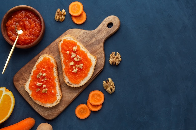 Sandwiches with carrot jam and walnut on a dark blue background