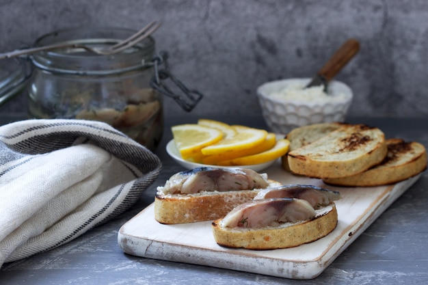 Sandwiches with cottage cheese and gravlax from mackerel, served with lemon.