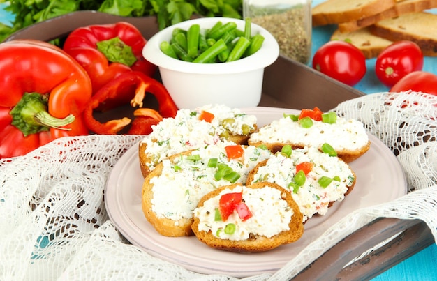 Sandwiches with cottage cheese and greens on plate on wooden table closeup