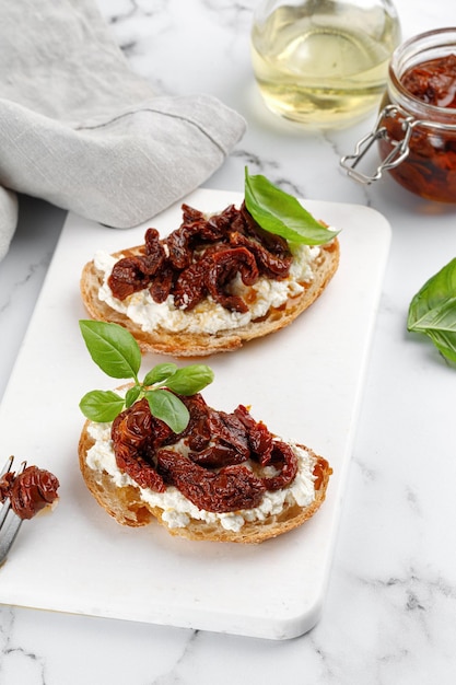 Sandwiches with cottage cheese ricotta cheese dried tomatoes and basil Bruschetta snack appetizers